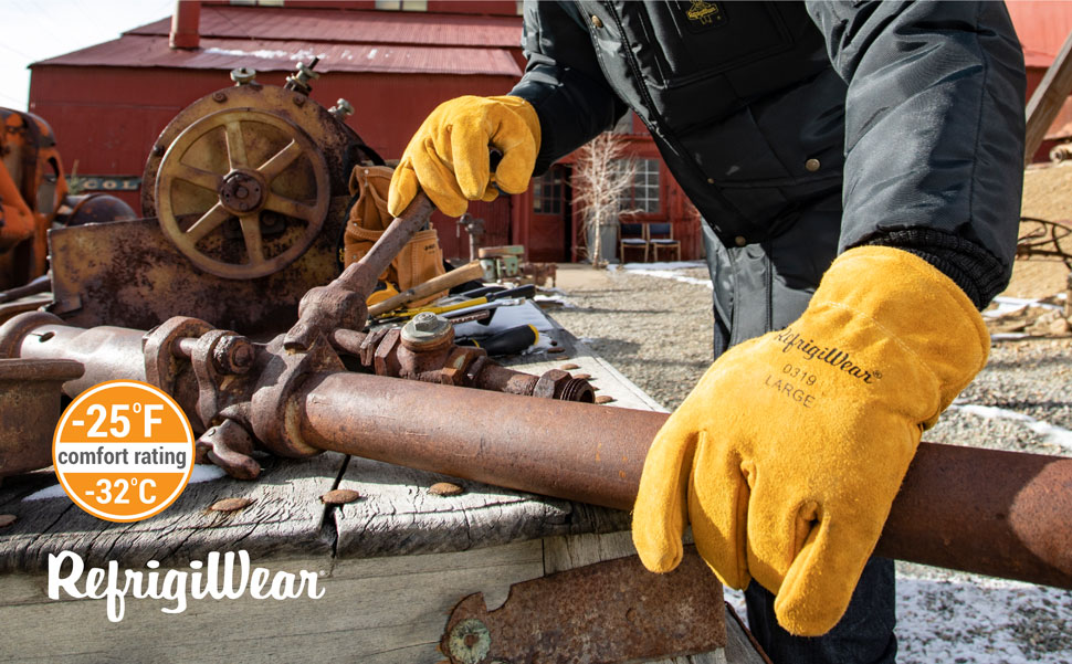 Man working outside in the cold on a pipe wearing Insulated cowhide leather gloves